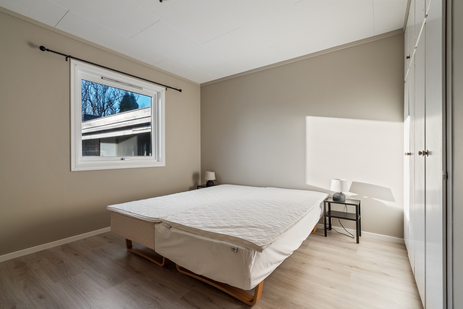 Dobbelt soverom med nytt laminatgulv (samme type som i gang og stue), to doble innebygde garderobeskap med fire småskap over. Galleribilde