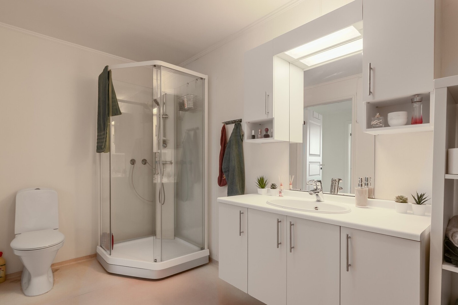 Praktisk og stort bad på 9,5 m², utstyrt med servant, servantskap, dusjhjørne, toalett, oppbevaringsmøblement og opplegg for vaskemaskin og tørketrommel. Galleribilde