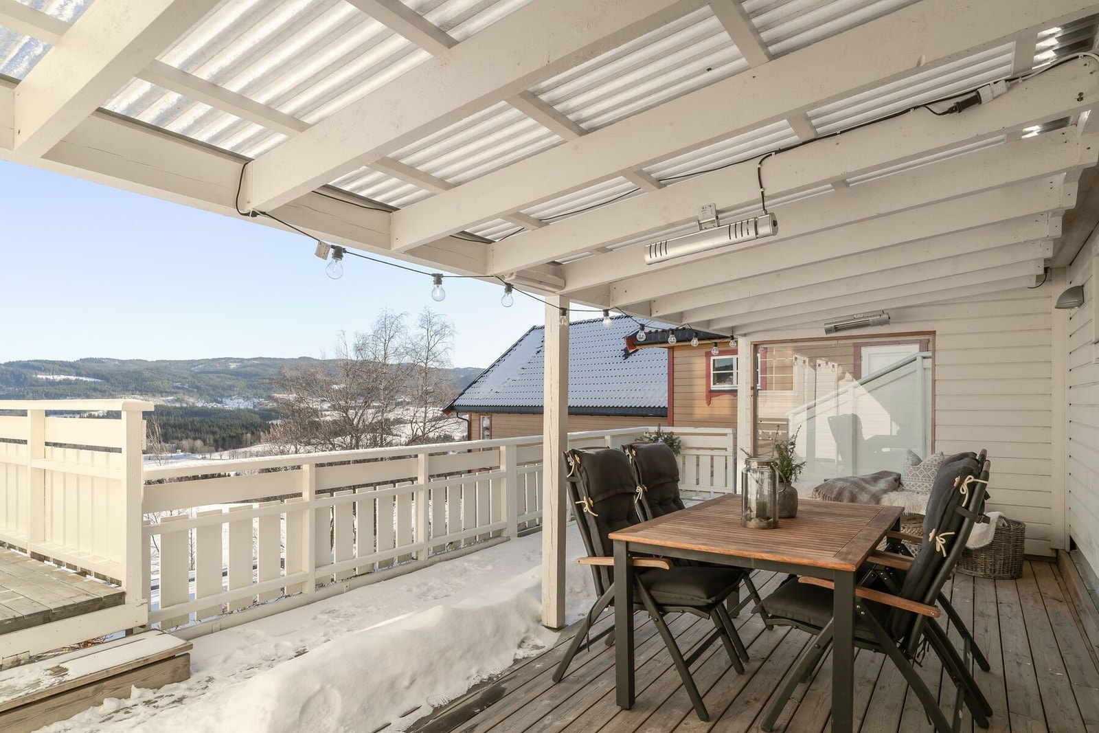 Åpen hagestue med takoverbygg - et lunt uterom som forlenger utesesongen. Hagestuen ligger tilknyttet garasjen og har takoverbygg med gjennomsiktige takplater. Galleribilde