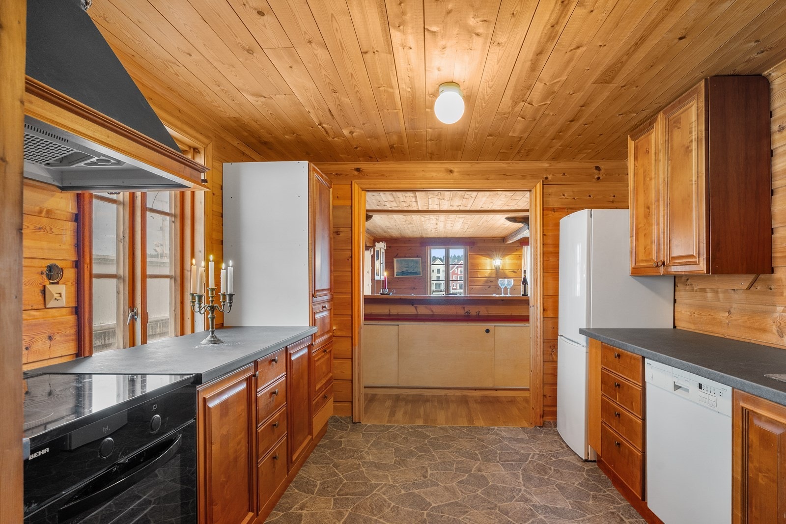 Tidløst og flott kjøkken med trestruktur og mørk benkeplate Galleribilde