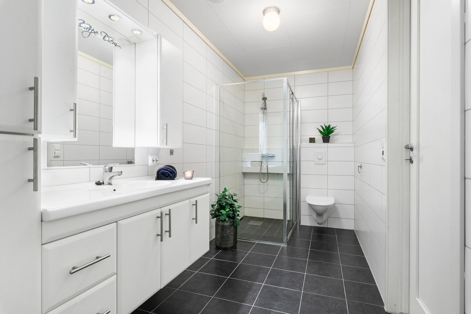 Romslig, flislagt baderom på ca 7m², baderommet er kombinert med vaskerom som er adskilt med skyvedør Galleribilde