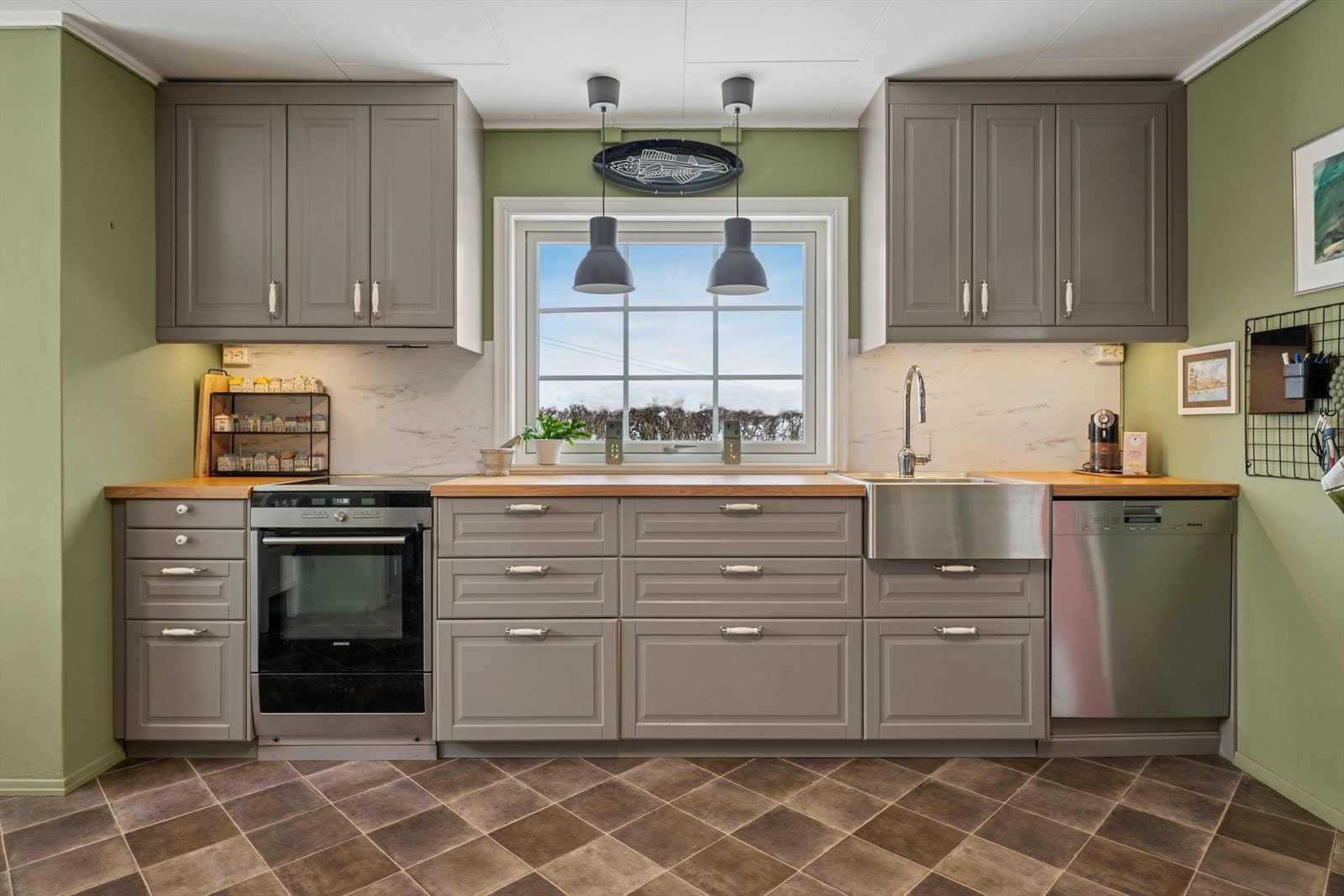 Kjøkkeninnredningen har rikelig med skap- og benkeplass. Galleribilde