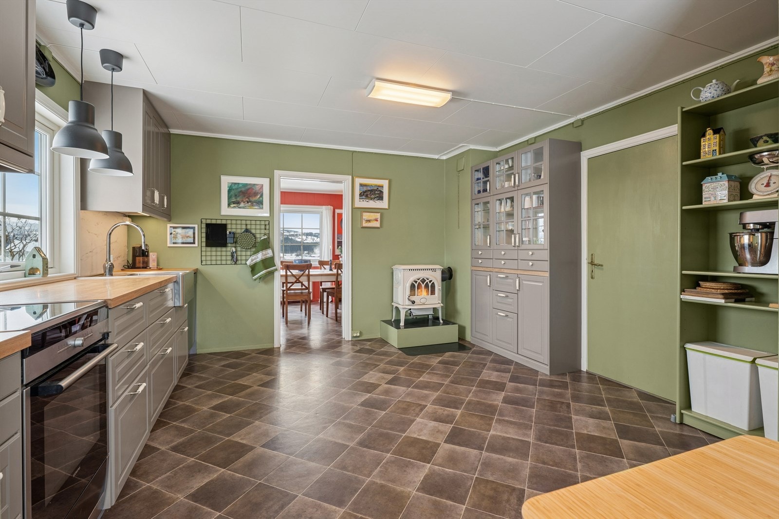 Romslig kjøkken praktisk plassert i et eget rom. En vedovn fra 2021 gir ekstra varme og en lun atmosfære. Galleribilde