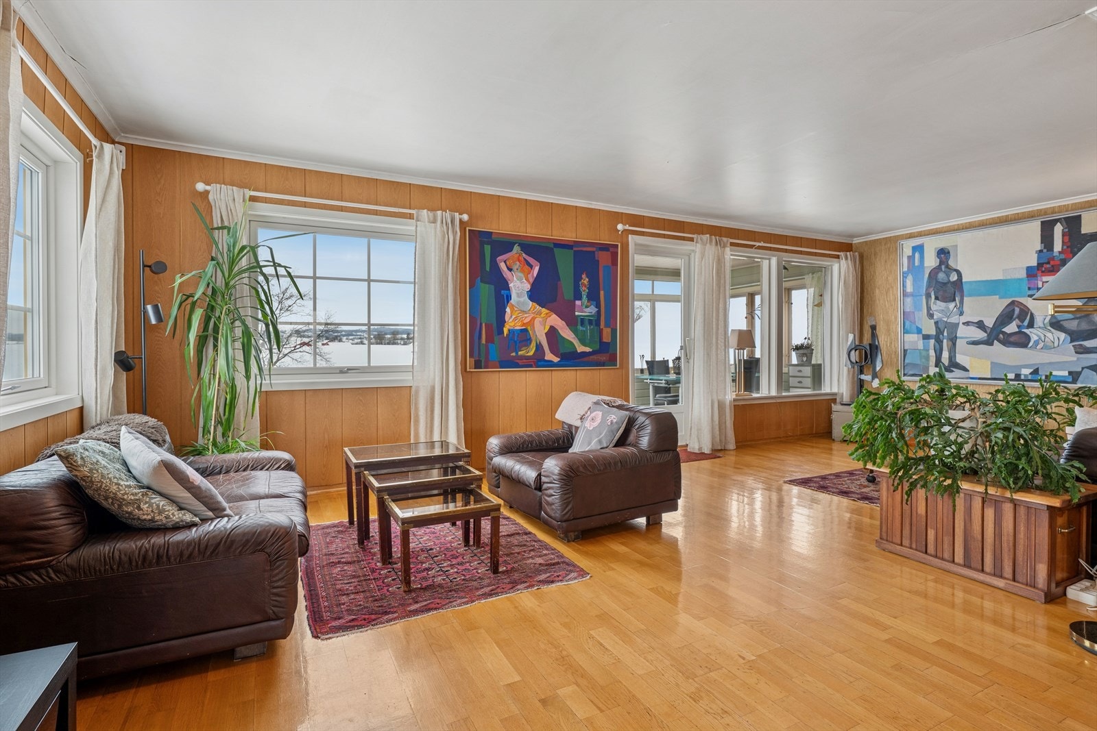 Romslig stue med parkett på gulv og god plass for flere sittegrupper. Galleribilde