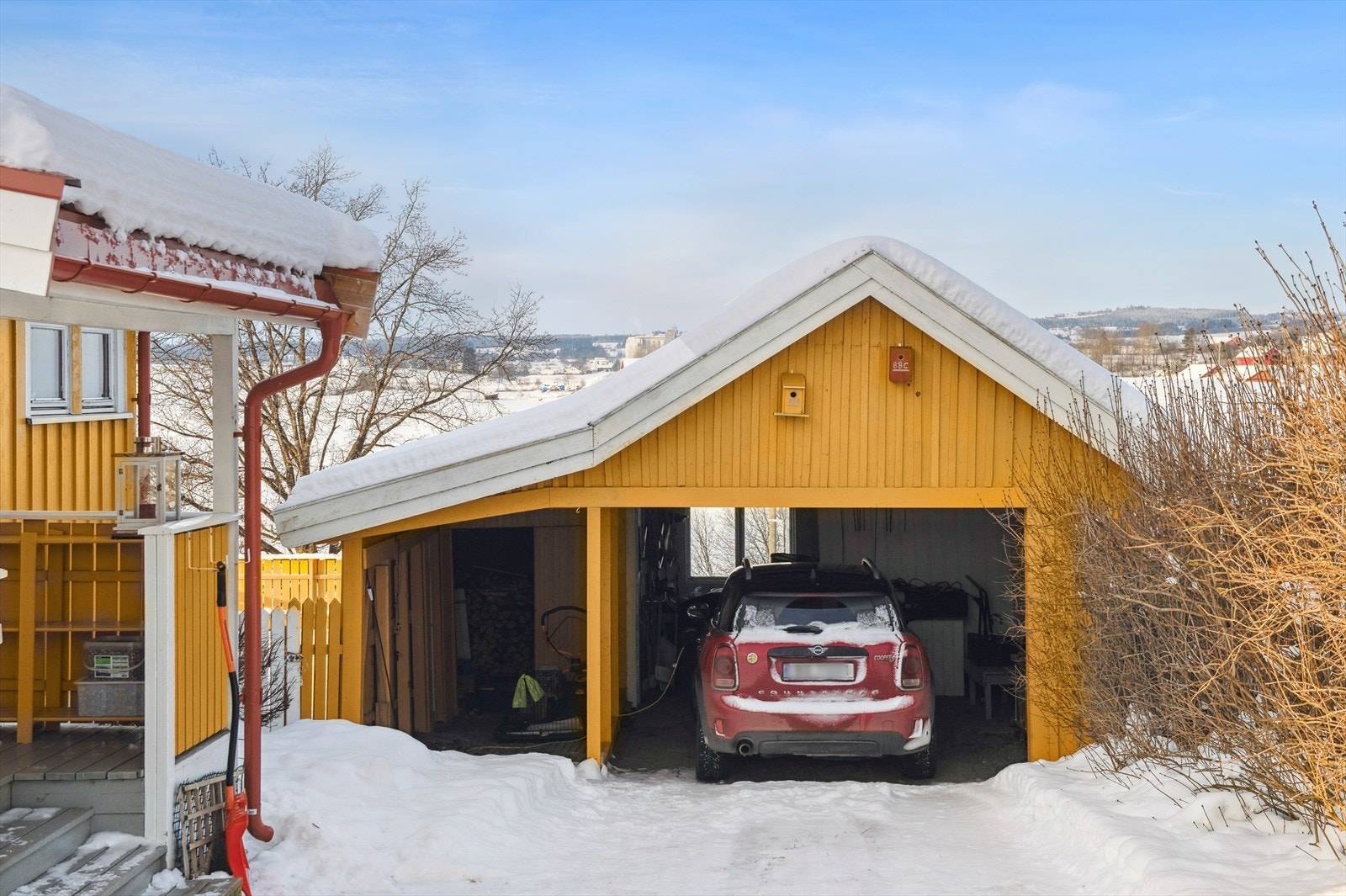 Eiendommen har en frittstående carport med plass til én bil og ekstra lagring. Galleribilde