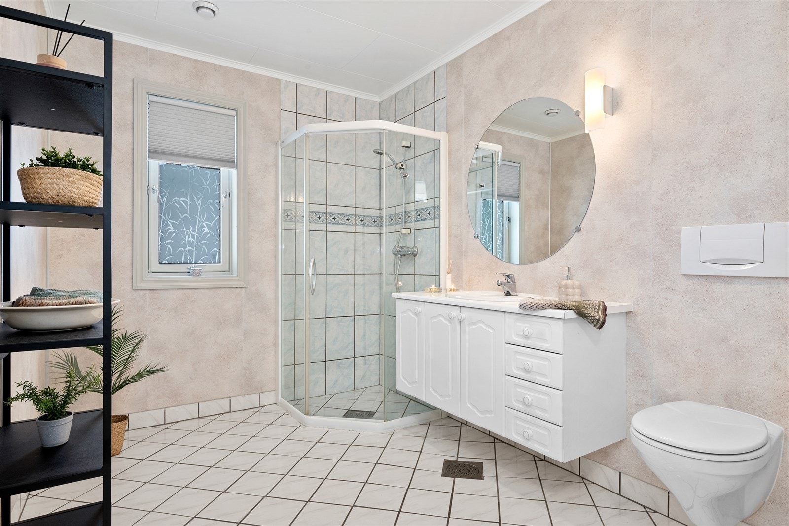 Badet har flislagt gulv og dusjsone, og baderomsplater på vegg. Innredningen er tidløs og har god plass til hygieneartikler. Galleribilde