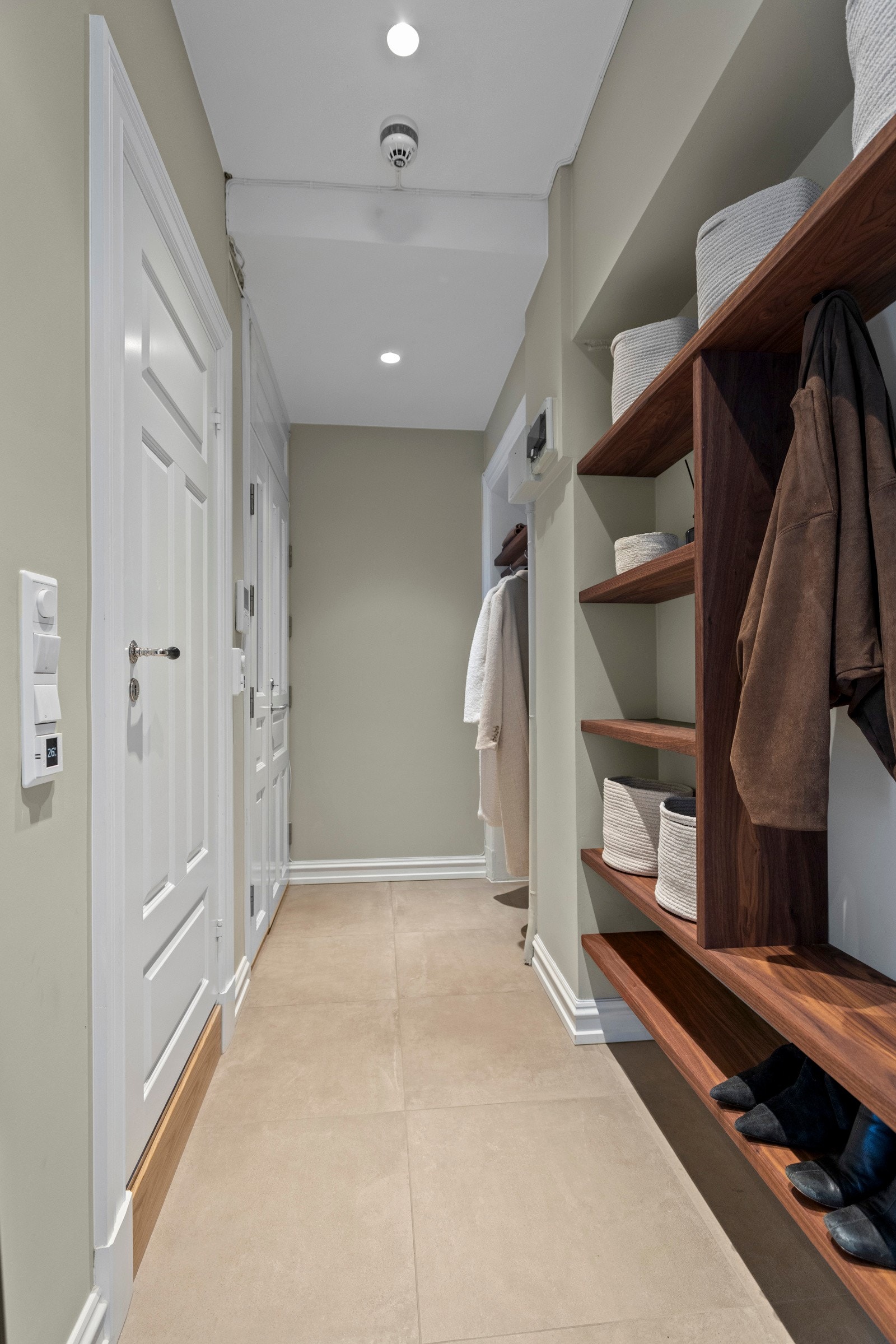 Innbydende entrè med plassbygde løsninger i Heltre valnøtt. Det er flislagt gulv med varme. Galleribilde