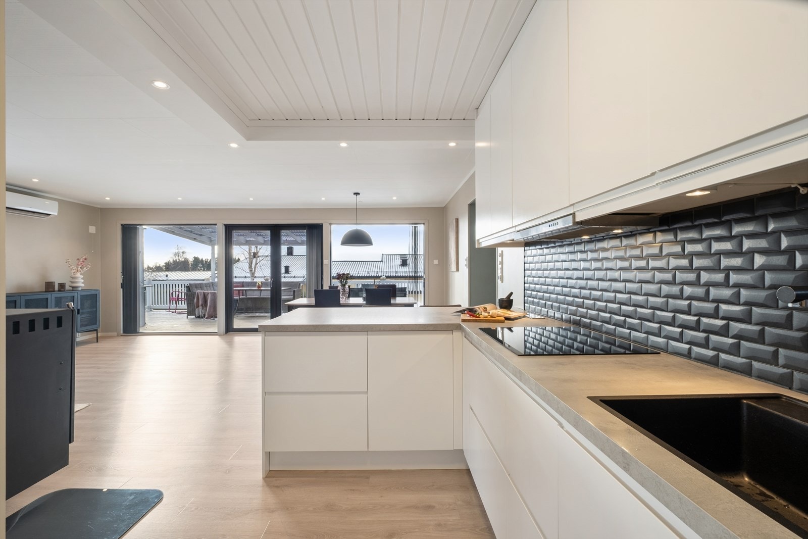 Lekkert og moderne kjøkken fra 2022 med slette fronter og en robust laminatbenkeplate. Galleribilde