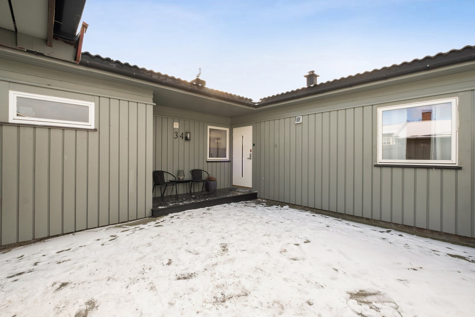 Overbygget inngangsparti med en terrasse på 5 m² og ny ytterdør fra 2024. Galleribilde