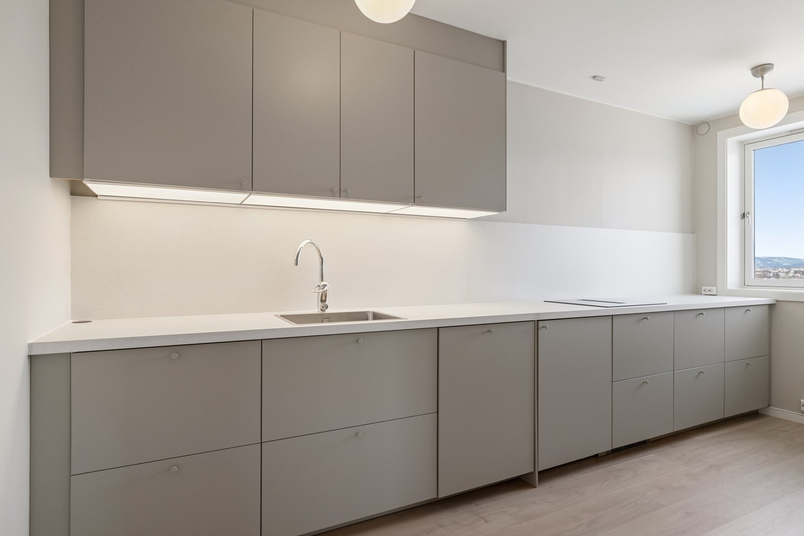 Kjøkkenet er nytt fra 2025, med en moderne og stilren innredning med malte, glatte fronter og integrerte hvitevarer. Det er vaskemaskin på kjøkken. Galleribilde