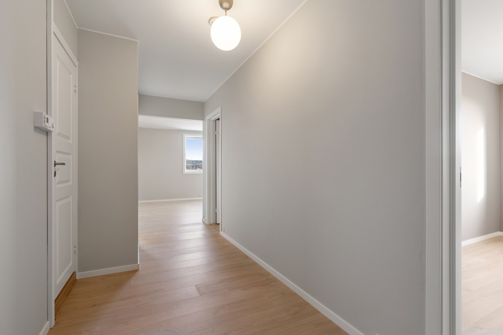 En lys og innbydende entré med nyoppussede overflater setter standarden for leiligheten. Galleribilde