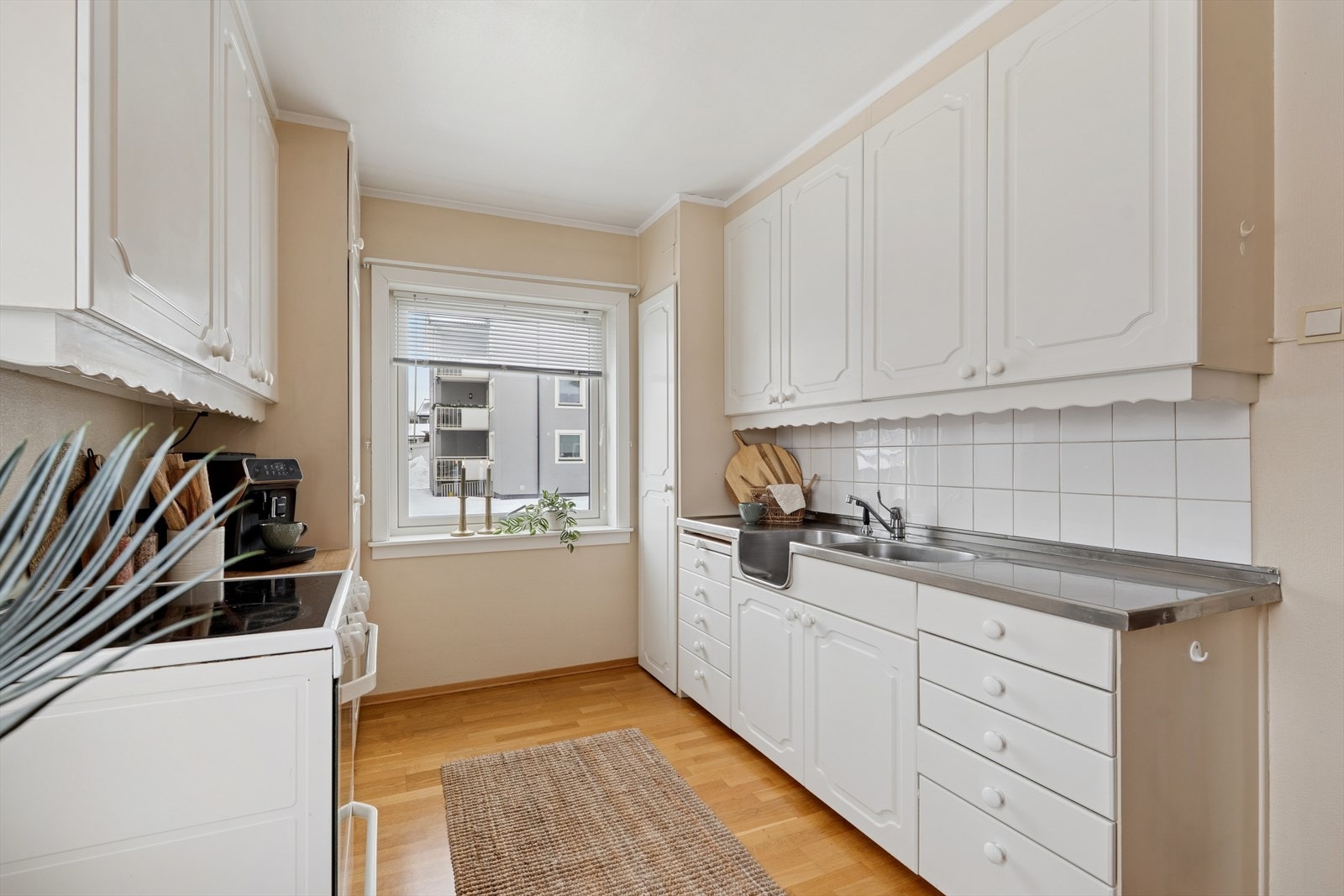 Kjøkkeninnredning i malt profilert utførelse og laminat benkeplate. Det er rustfri oppvaskbenk. Galleribilde