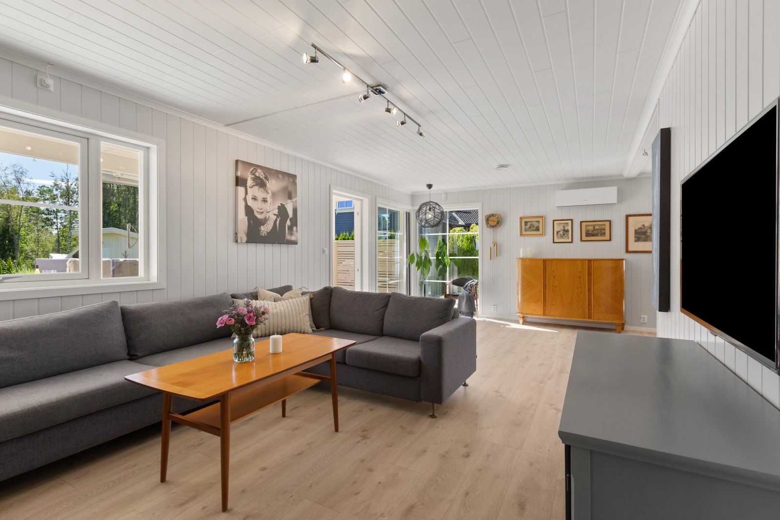 Stuen har flere store vindusflater som slipper inn rikelig med naturlig lys og bidrar til en lys, luftig og behagelig atmosfære i rommet. Galleribilde