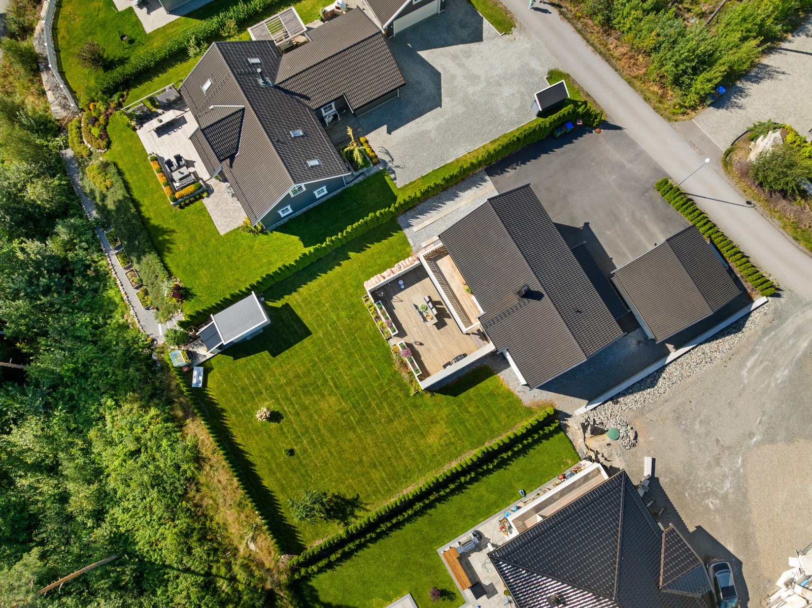 Solrik tomt som er pent opparbeidet med stor gressplen omkranset av hekk, diverse beplantning, samt en stor uteplass og frittliggende bod. Galleribilde