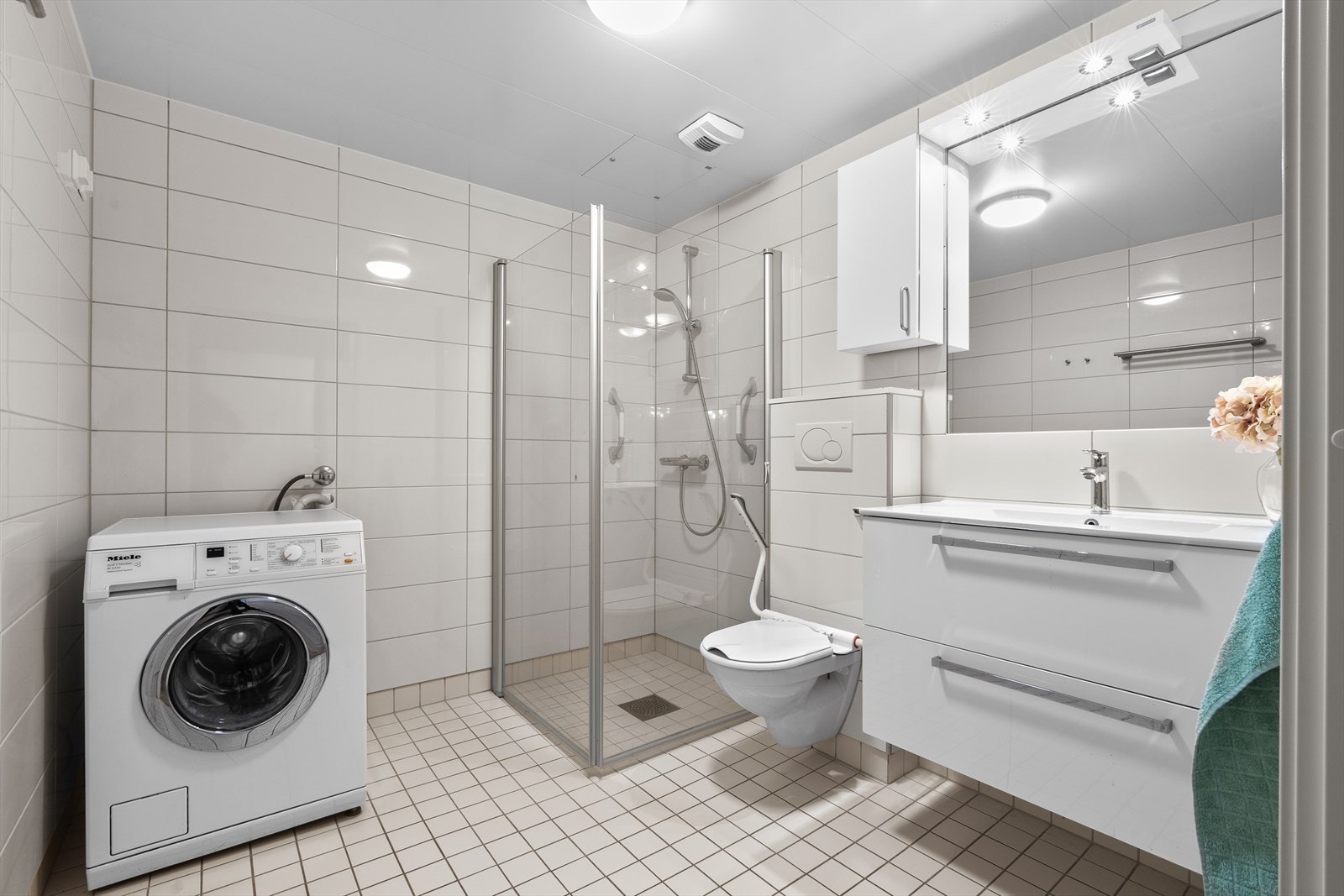 Pent bad med gulvvarme, servant med skap og vegghengt toalett. Innfellbare dusjvegger og opplegg og plass for både vaskemaskin og tørketrommel. Galleribilde