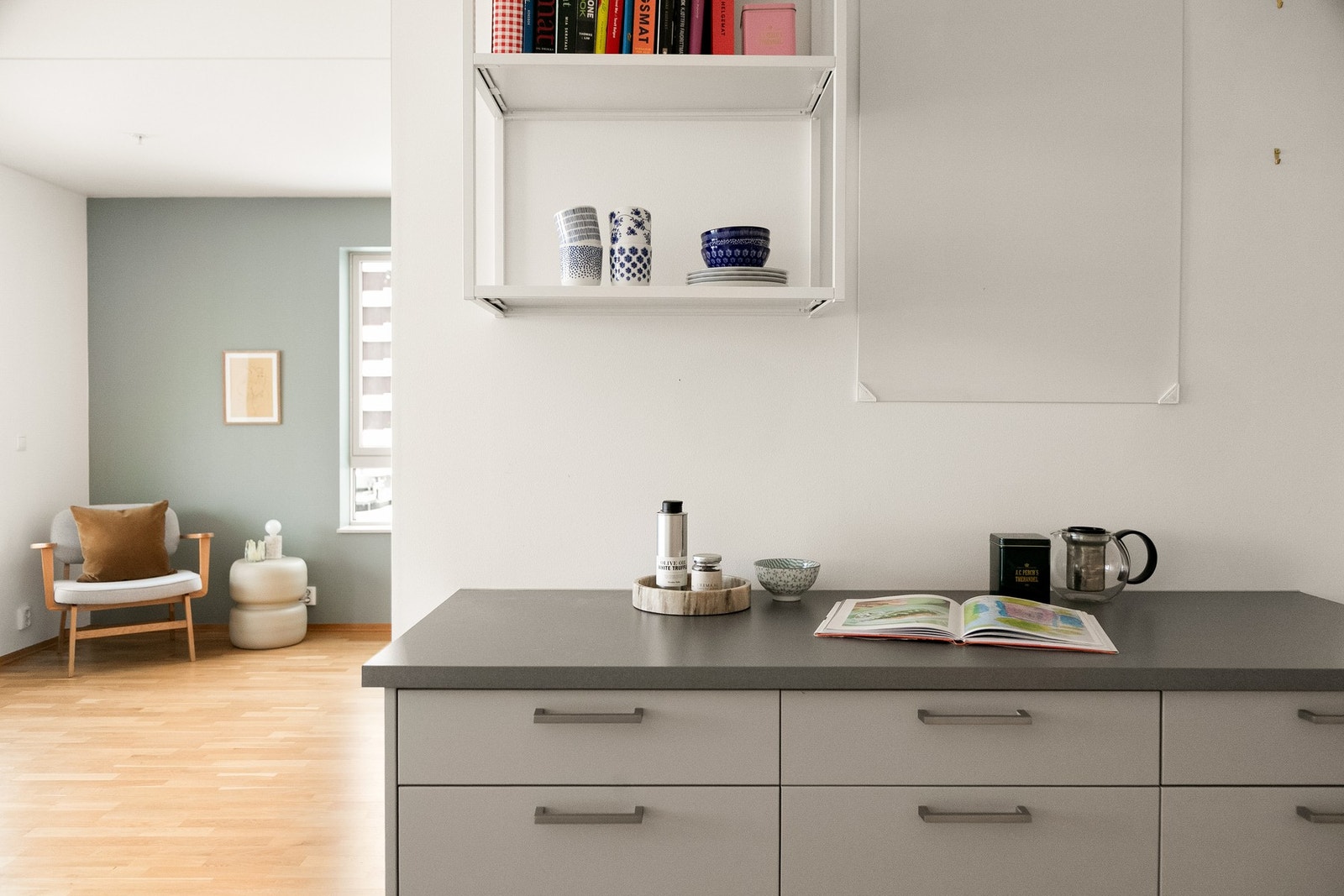 Kjøkkeninnredningen er utstyrt med stilrene glatte fronter, benkeplate med nedfelt kum i rustfritt stål og ledlys under overskap. Galleribilde