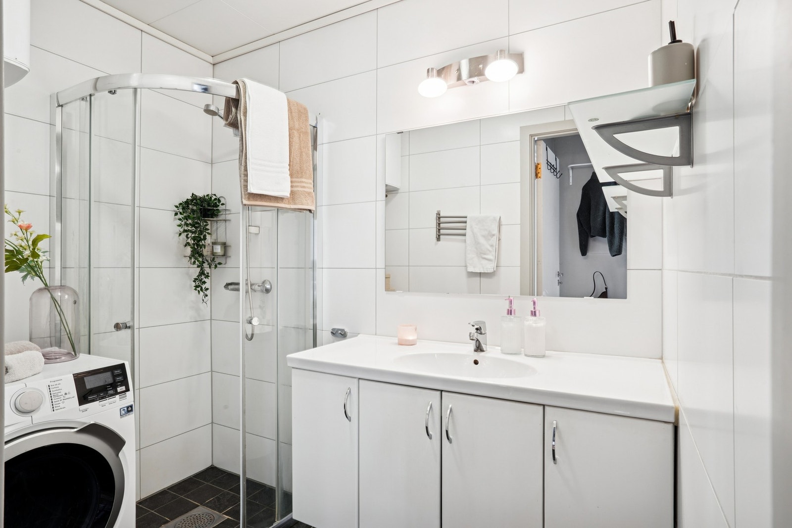 Flislagt bad med elektriske varmekabler, eget dusjhjørne, baderomsinnredning med oppbevaring og opplegg for vaskemaskin. Galleribilde