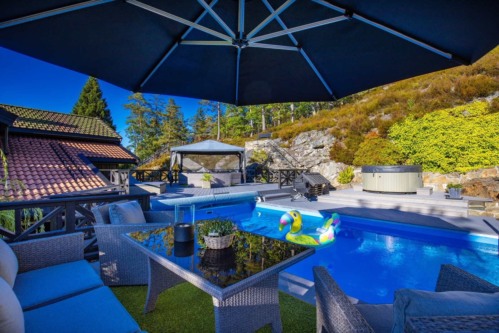 Svømmebasseng med omkranset terrasse og jacuzzi som medfølger. Galleribilde