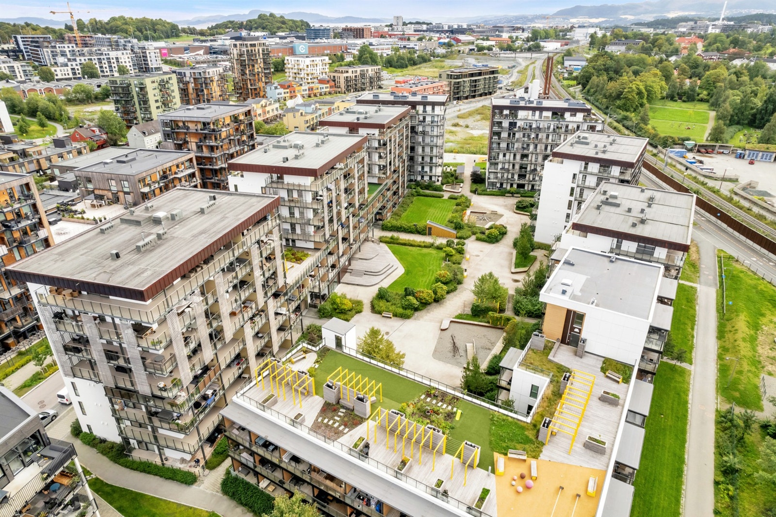 Mellom blokkene og i fellesarealet til sameiet er det velholdt og opparbeidet med benker, internstier og frodige vekster som på sommerhalvåret blomstrer i flere ulike fargekombinasjoner. Galleribilde