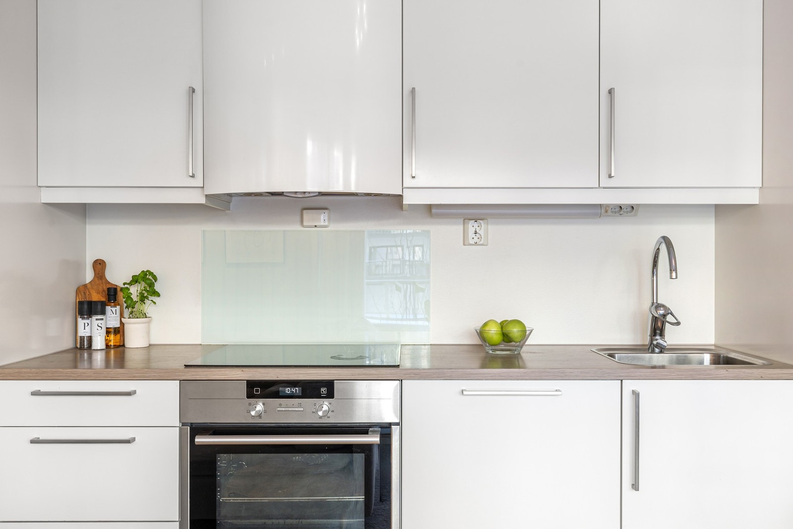 Kjøkkenventilator over stekesone har avtrekk via boligens balanserte ventilasjonsanlegg. Legg merke til den praktiske beskyttelsesplaten bak stekesonen. Galleribilde