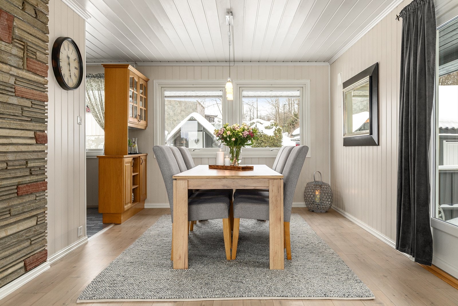 Lys og innbydende spisestue med store vindusflater som slipper inn rikelig med dagslys. Her er det god plass til hyggelige måltider rundt spisebordet, med lun atmosfære og fine detaljer som skaper en hjemmekoselig følelse. Galleribilde