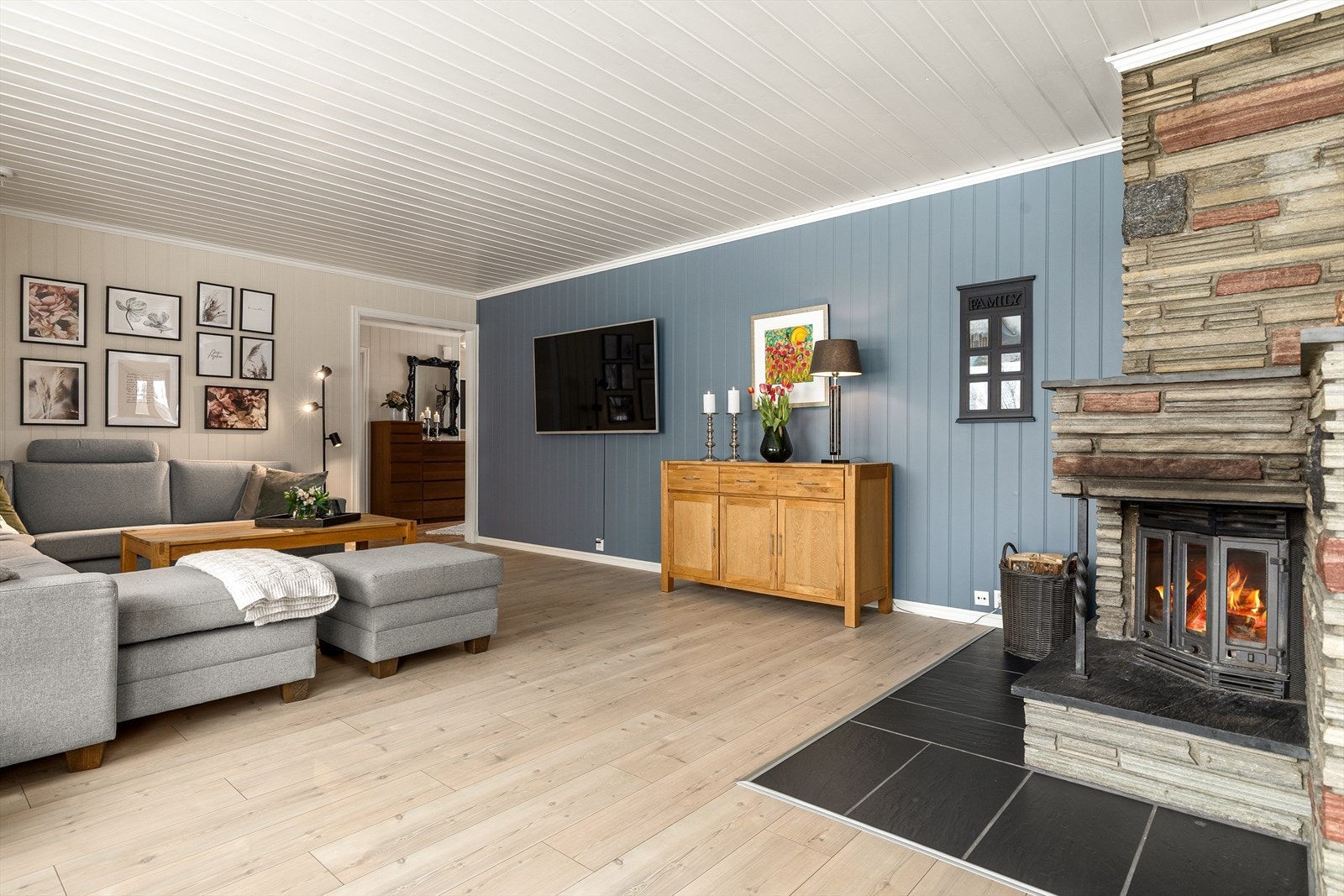 Stuen har god plass til både sofagruppe og TV-sone. Peisen gir ekstra varme og skaper en hyggelig stemning i rommet. Galleribilde