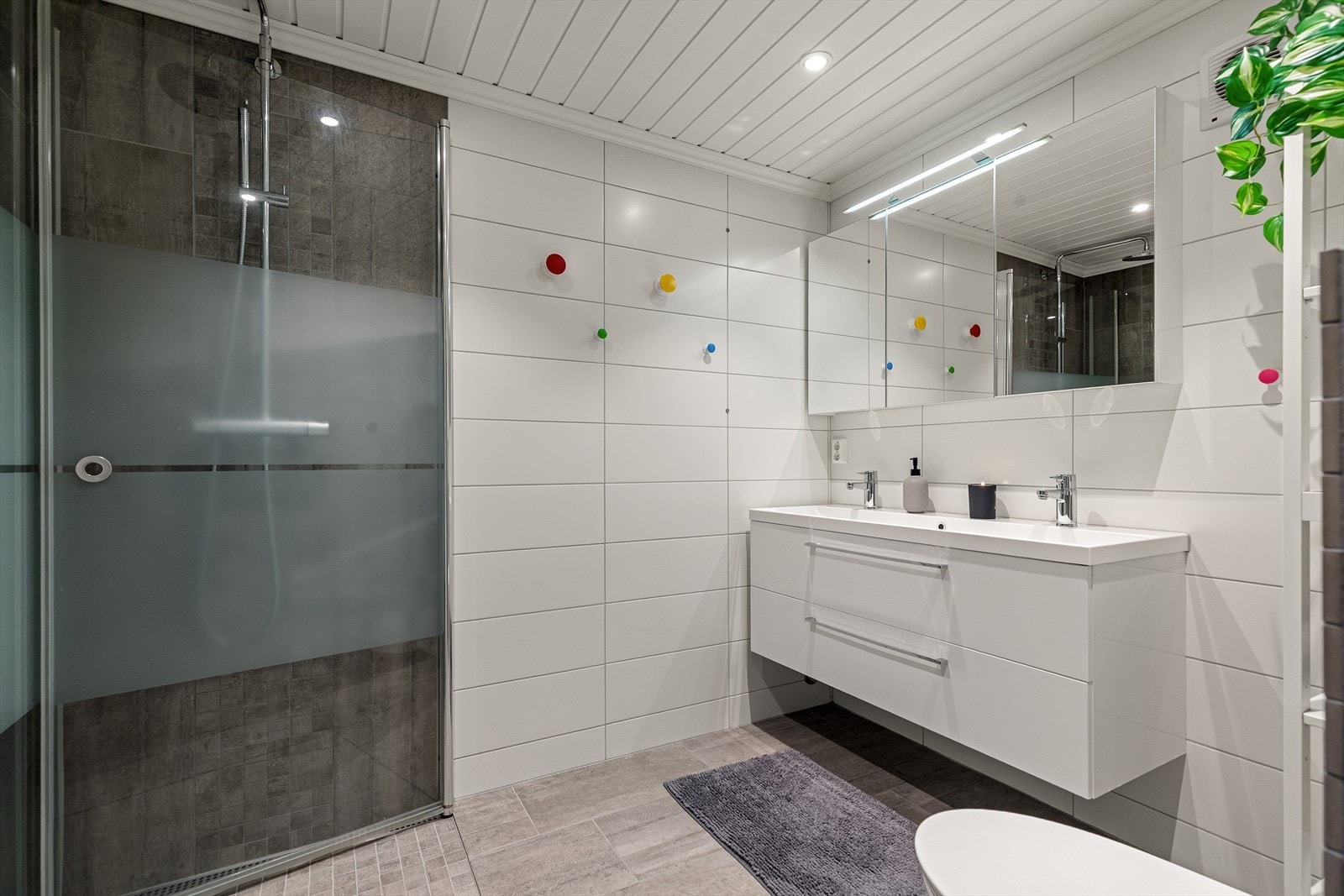 Stilrent og romslig bad med stor dusjnisje, dobbel servant og rikelig med speil og skapplass. Et bad som fungerer godt i hverdagen for flere samtidig. Galleribilde