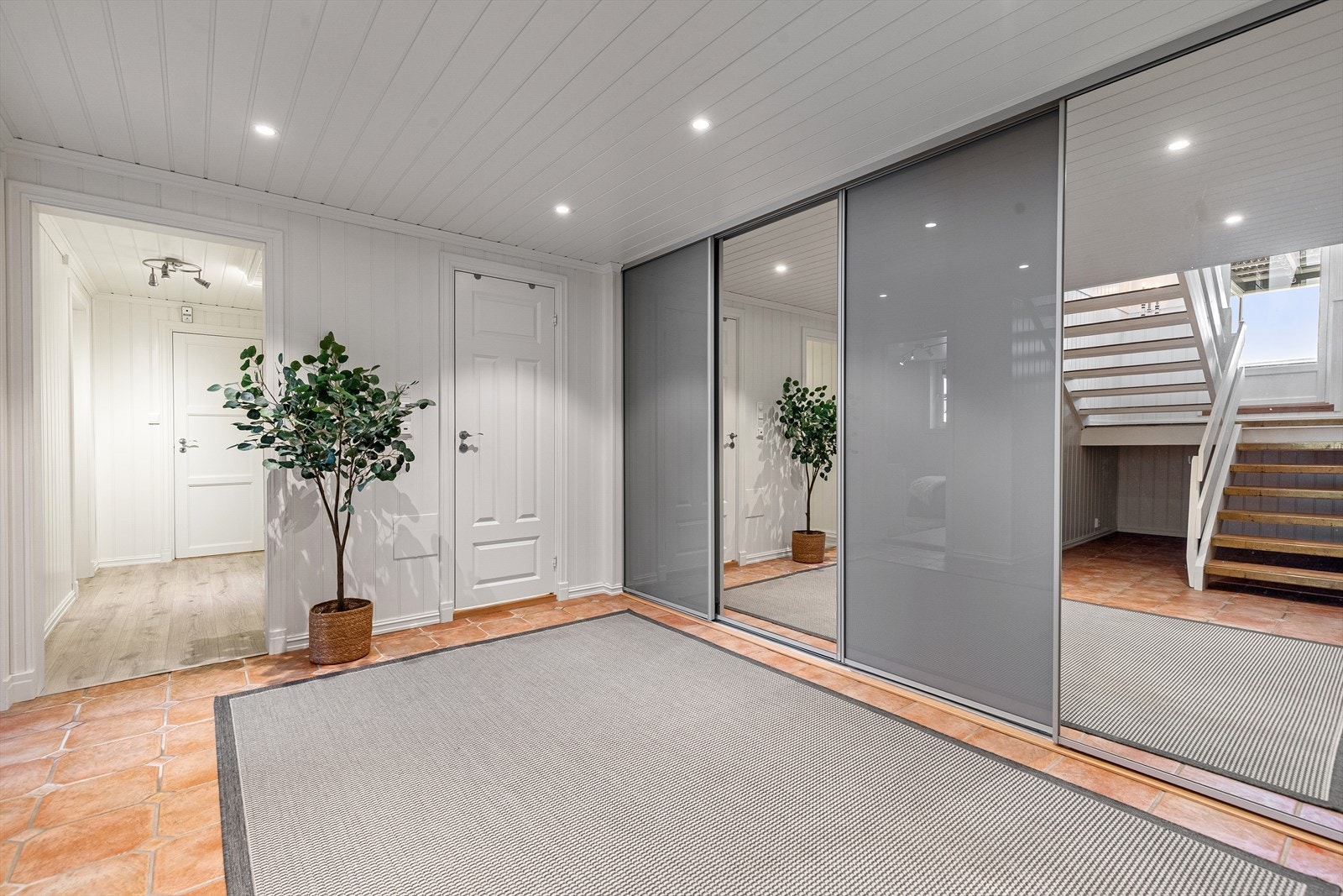 Romslig entré med praktisk skyvedørsgarderobe med speilfronter og gode oppbevaringsmuligheter. Galleribilde