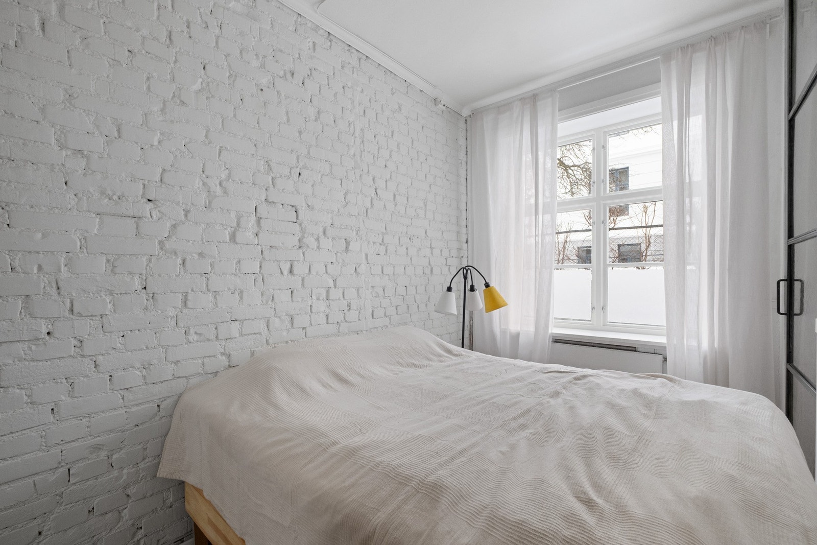 En behandlet teglsteinsvegg på soverommet spiller sammen med lune og lekre gulv og skaper en behagelig atmosfære. Galleribilde