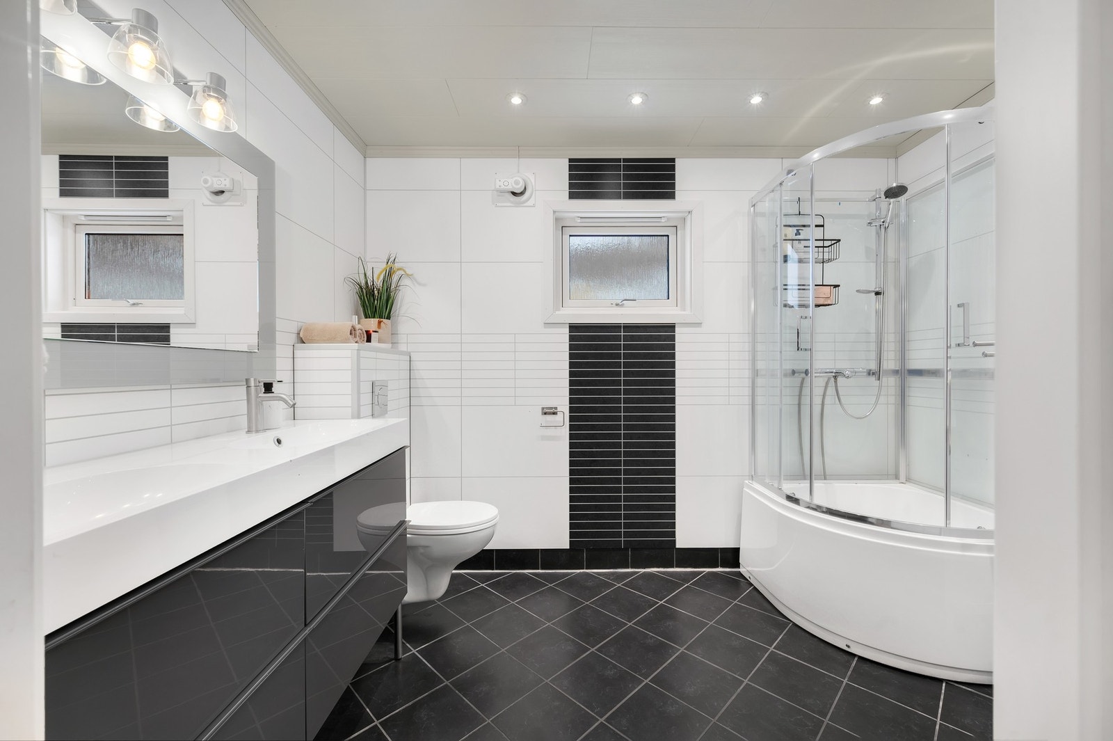 - Pent flislagt bad med romslig innredning og innsatt dusjkabinett. Galleribilde
