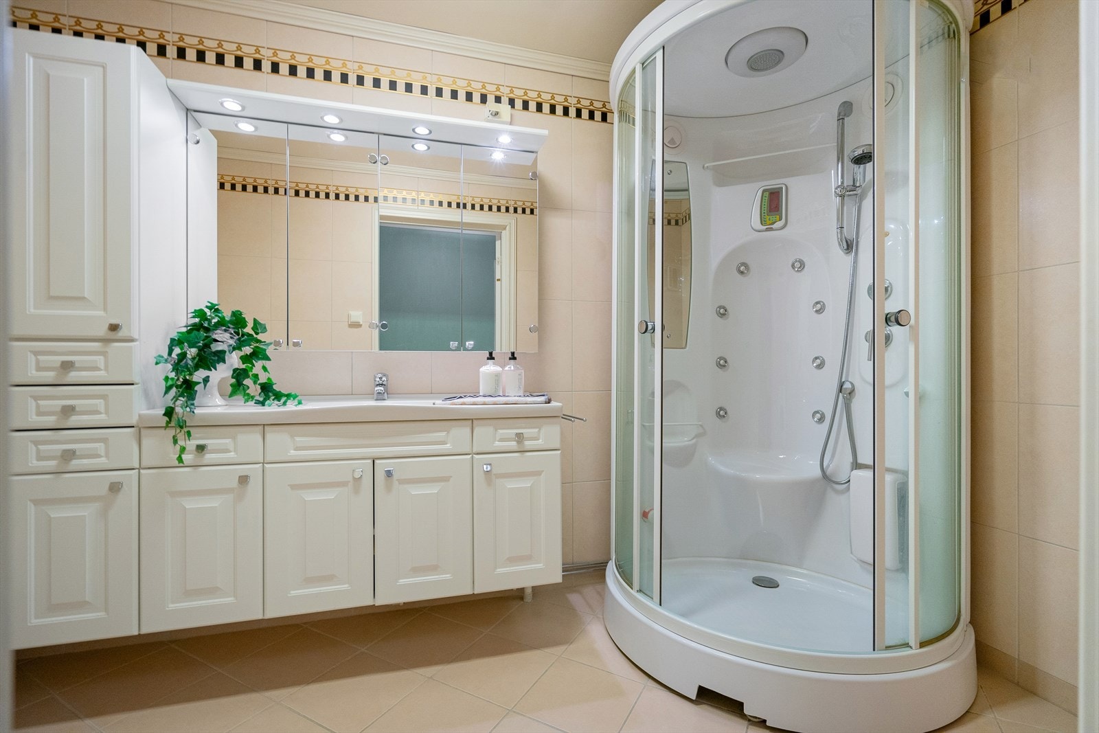 Bad med stor innredning, speilskap og dusjkabinett. Galleribilde