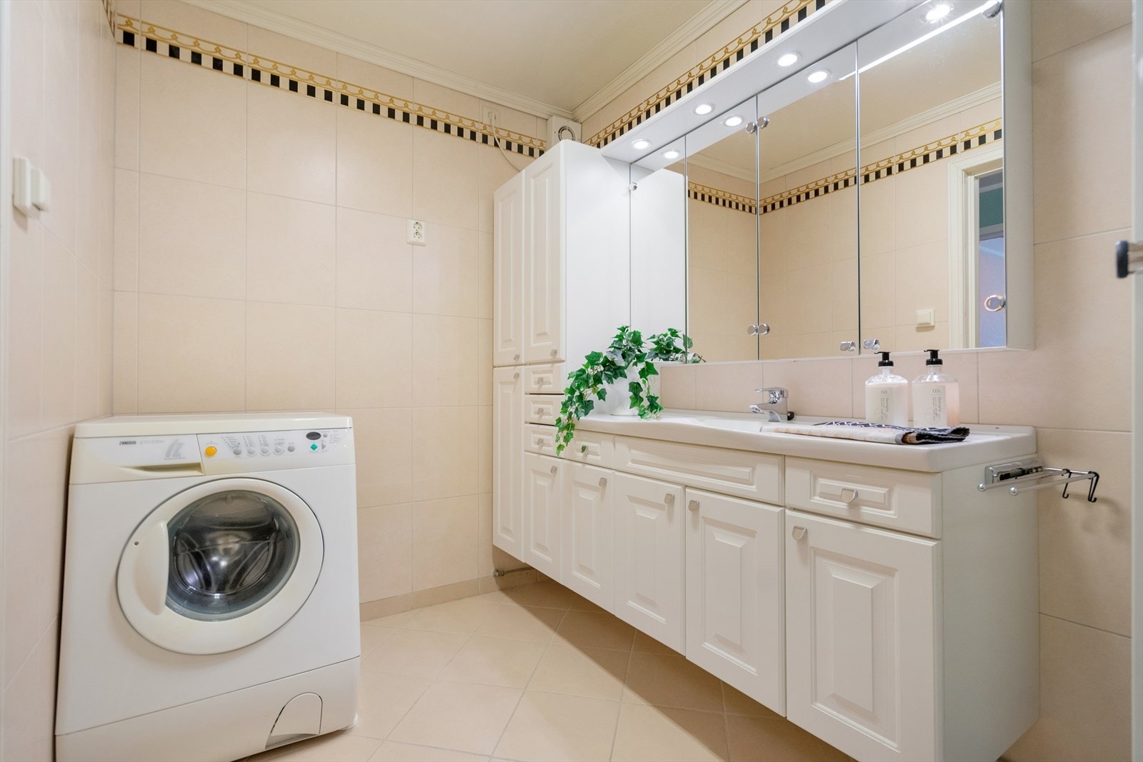 Flislagt bad med gulvvarme og opplegg for vaskemaskin. Galleribilde