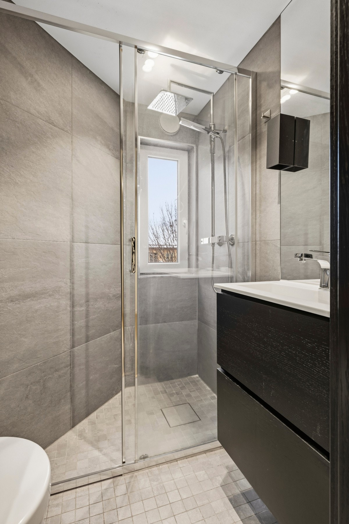 Badet er fra 2017 innredet med dusj nisje med skyve glassdører, vegg hengt toalett og innredning med nedsunket servant med speil. Galleribilde