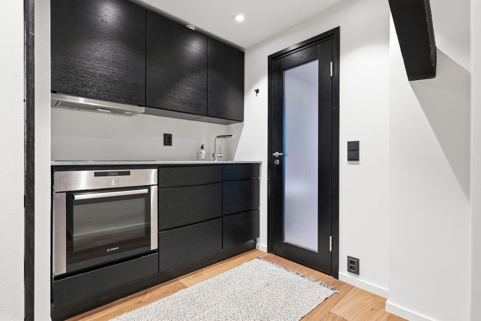 Kjøkkenløsning fra Kvik med glatte fronter, laminat benkeplate med integrert vask, godt med skap/benkeplass og integrerte hvitevarer. Galleribilde