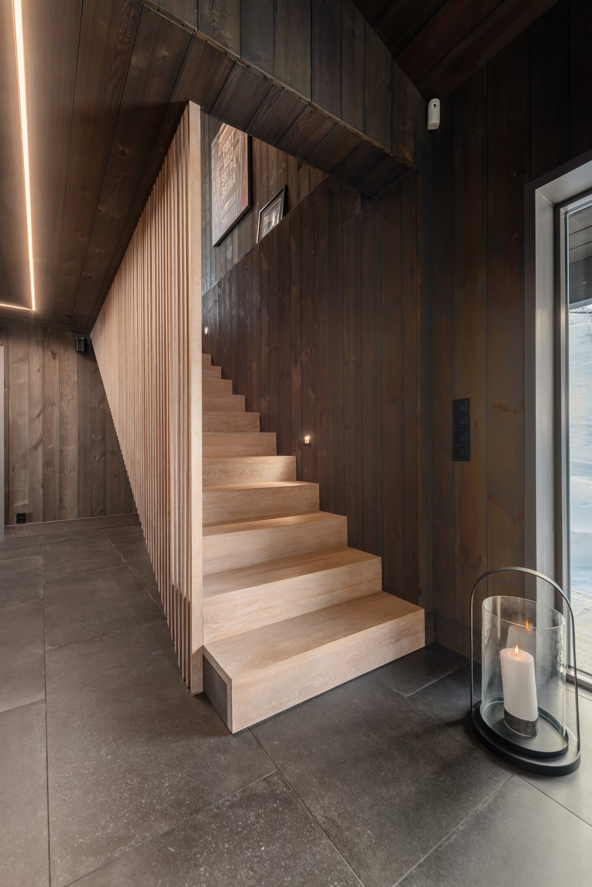 Trappene i seg selv er et smykke med eikespiler og soft lyssetting Galleribilde
