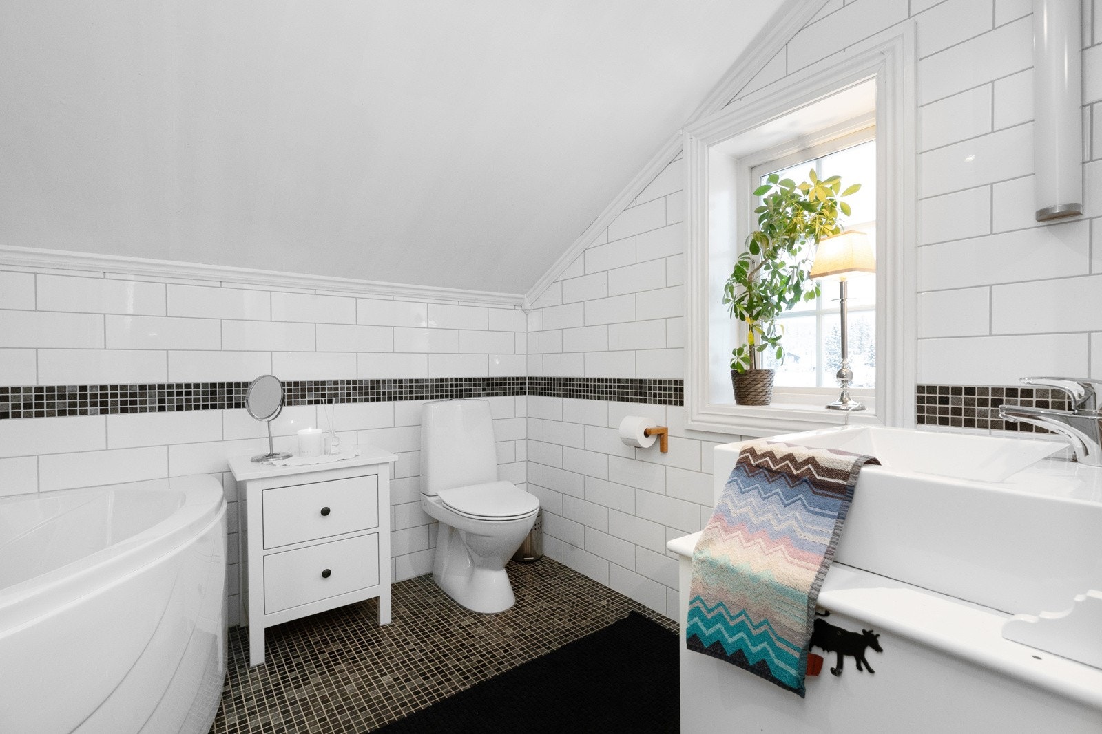 Veggene har fire rader med samme type mosaikk som gir rommet et pent uttrykk Galleribilde