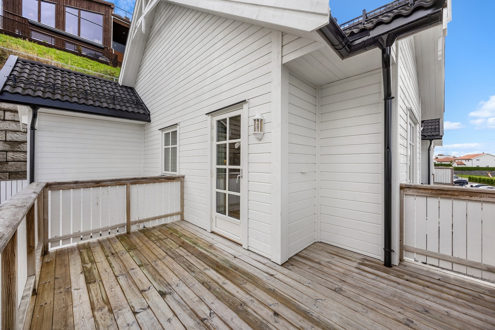 Terrassen har dekke i tre, og det er montert utebelysning på husveggen. I enden av terrassen og mot inngangspartiet er det en utebod. Boden har adkomst fra bakkeplan. Galleribilde