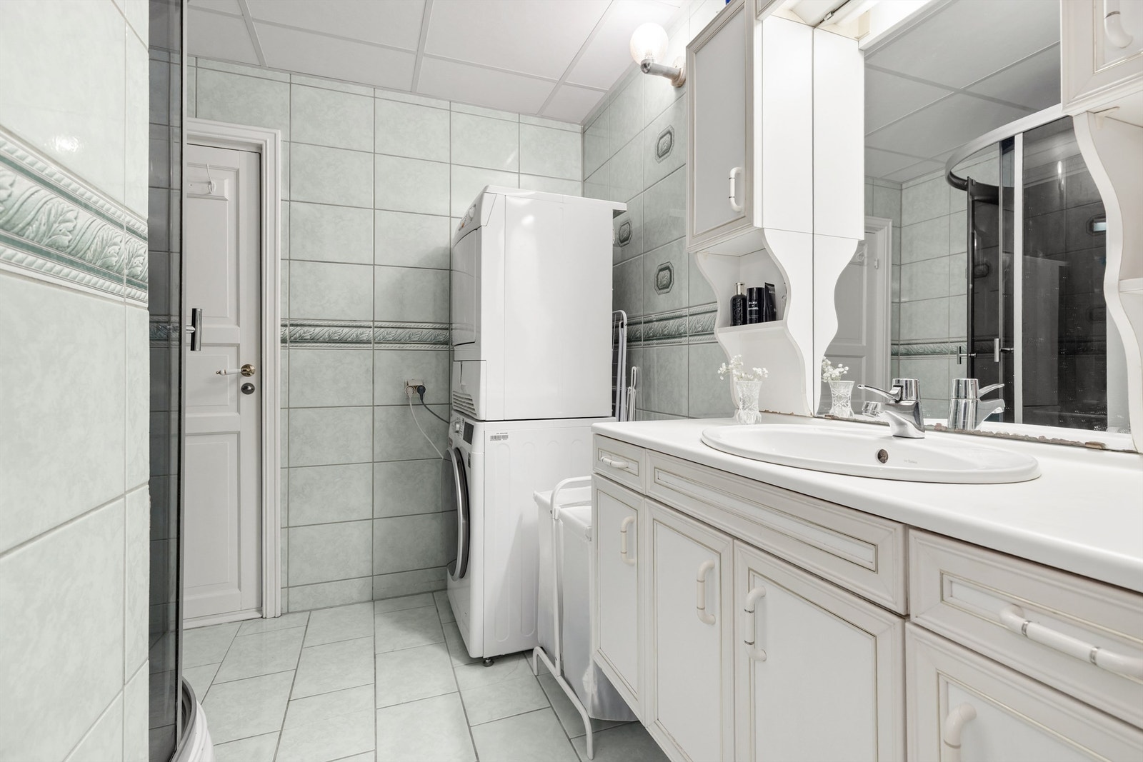 Badet har flislagt gulv og vegger, og er innredet med servantinnredning og dusjkabinett. Galleribilde