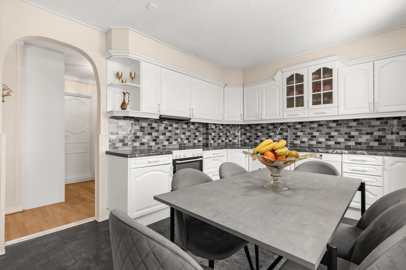 Kjøkkeninnredningen har profilerte fronter og en benkeplate med laminert overflate. Galleribilde