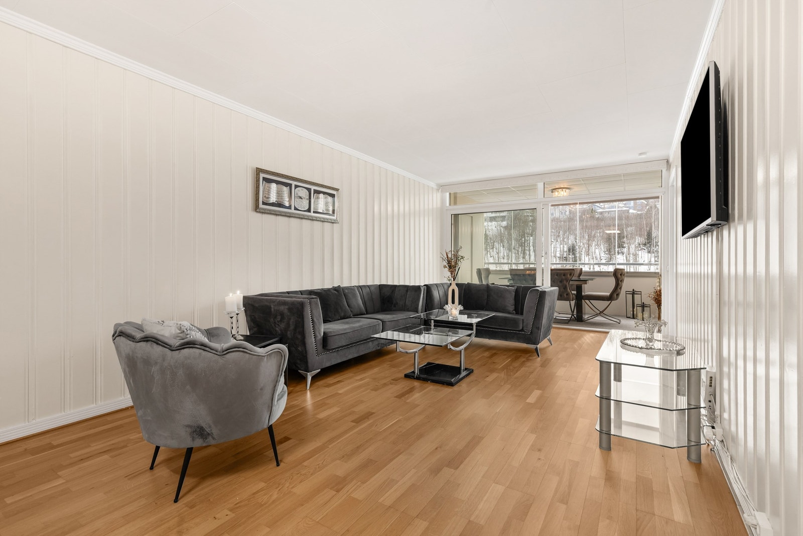 Stuen har parkett på gulvet, malt panel på veggene og god plass til en romslig sofagruppe. Galleribilde