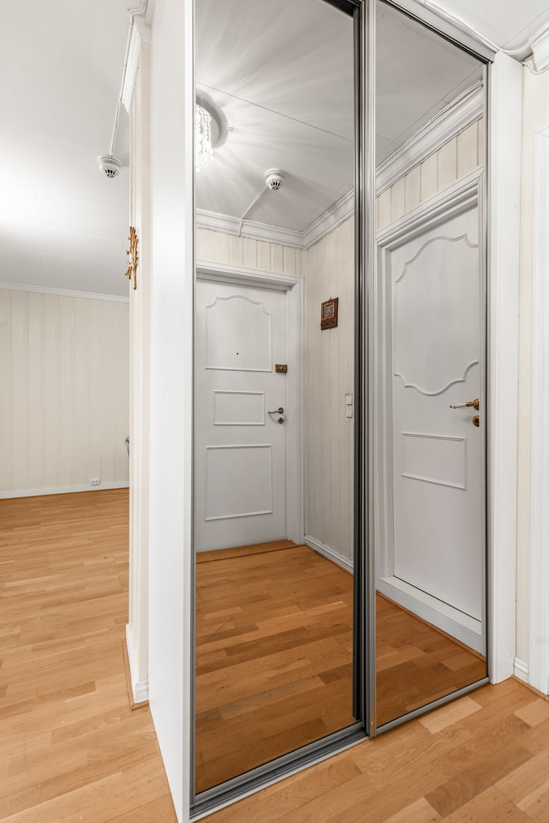 Praktisk skyvedørsgarderobe med speilfronter gir rikelig med oppbevaringsplass i gangen. Galleribilde