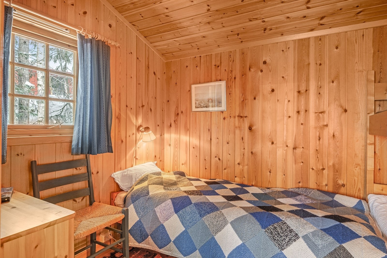 Soverommet har lakkerte tregulv og trepanel på veggene. Galleribilde