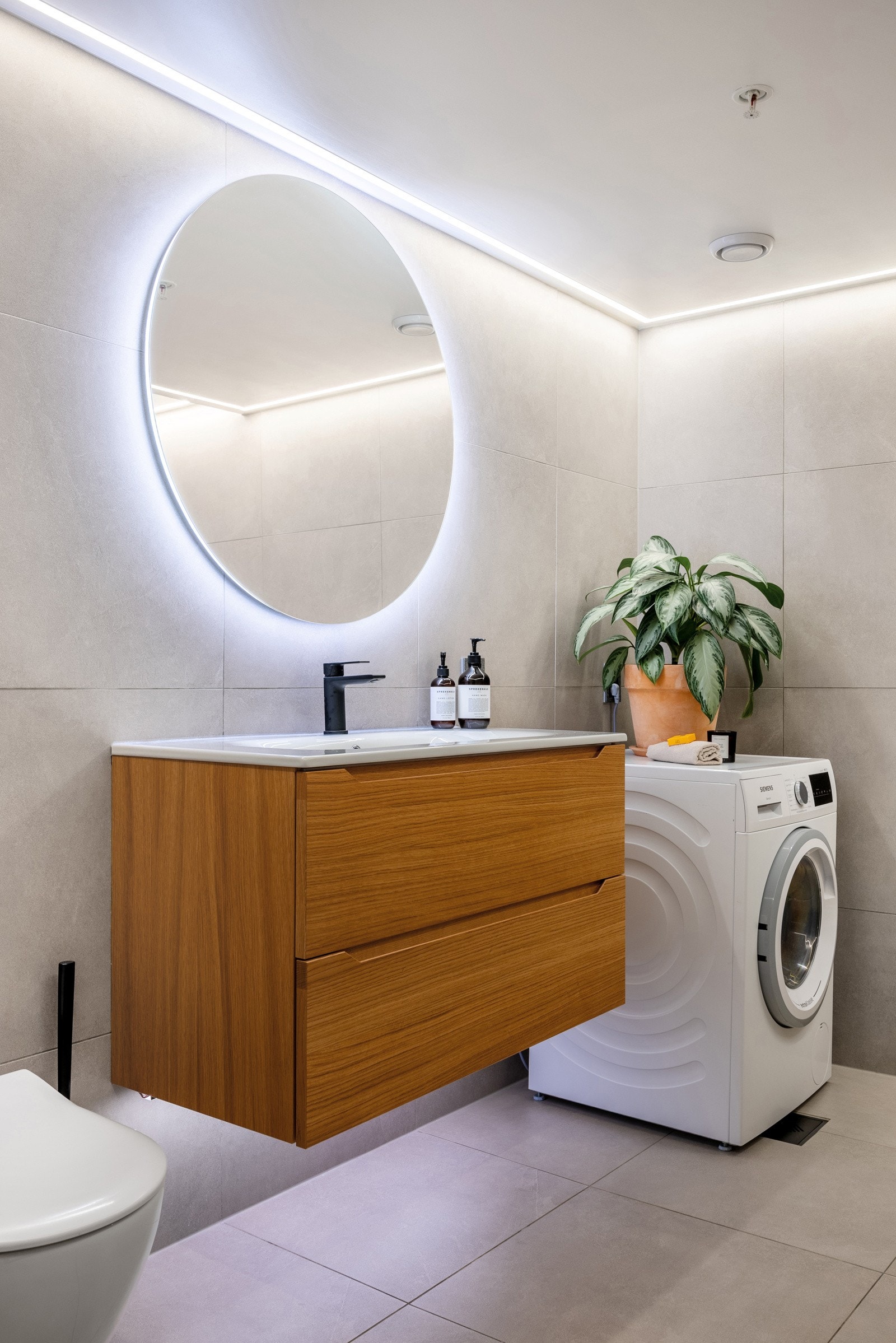 - Vegghengt toalett, servant med skap, speil med lys og opplegg for vaskemaskin og tørketrommel - Galleribilde