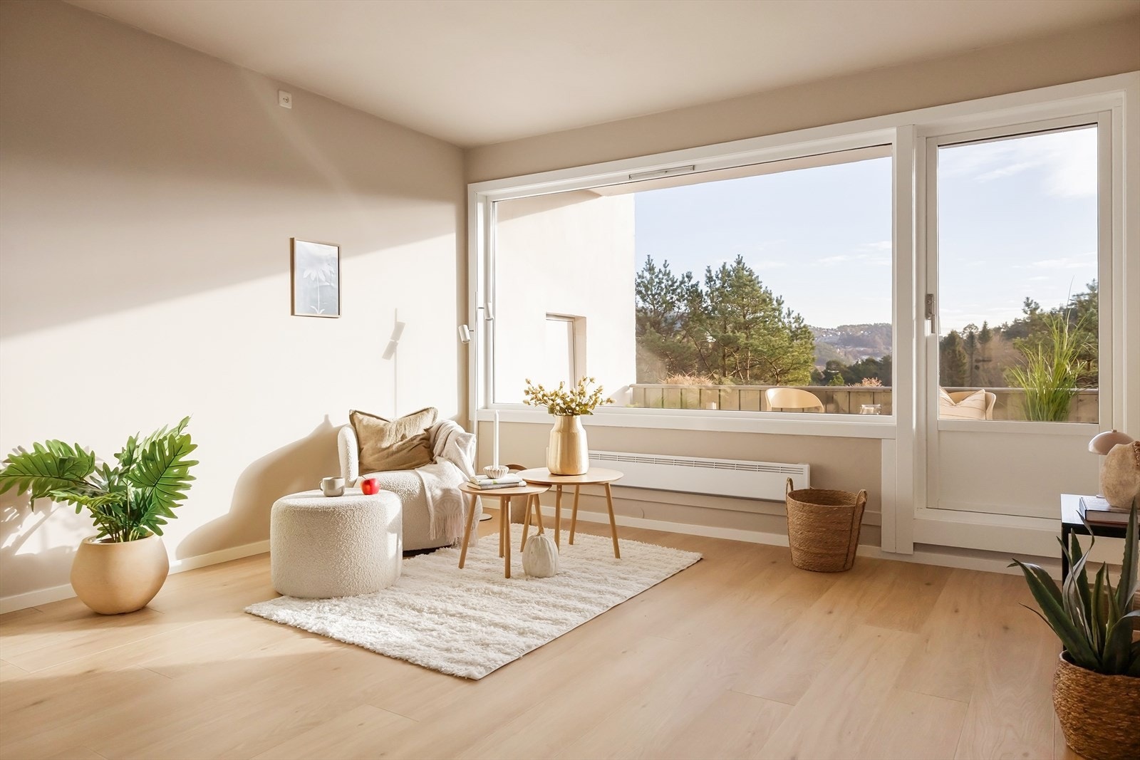 Fra stuen er det direkte utgang til en terrasse via en glassdør som står åpen, og utenfor ser man grønne omgivelser og en flott, skjermet utsikt mot åser og natur. Galleribilde