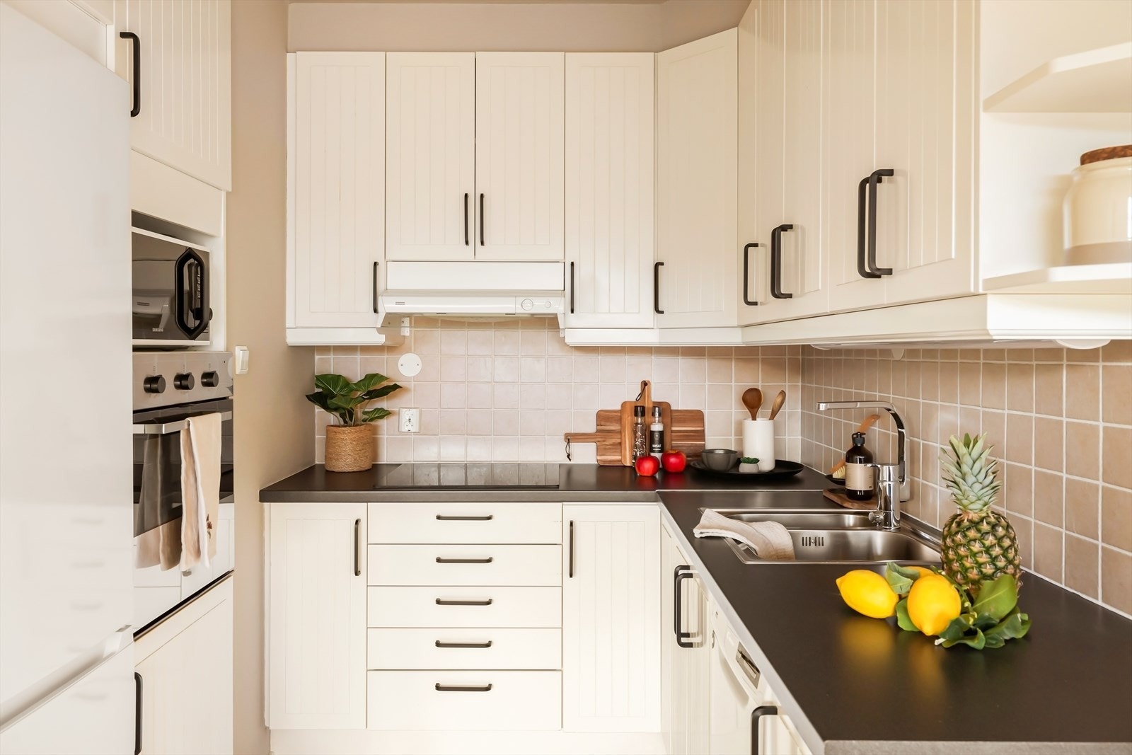 Kjøkkenet fremstår lyst, helhetlig og funksjonelt med en tidløs stil. Innredningen har profilerte, hvite fronter som gir et klassisk uttrykk Galleribilde