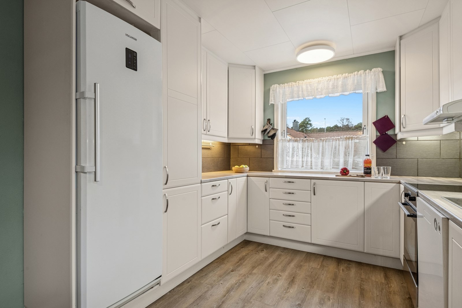 Kjøkkenet fremstår som både funksjonelt og tidløst, med en klassisk innredning med profilerte fronter som gir rommet et varmt og pent uttrykk. Galleribilde