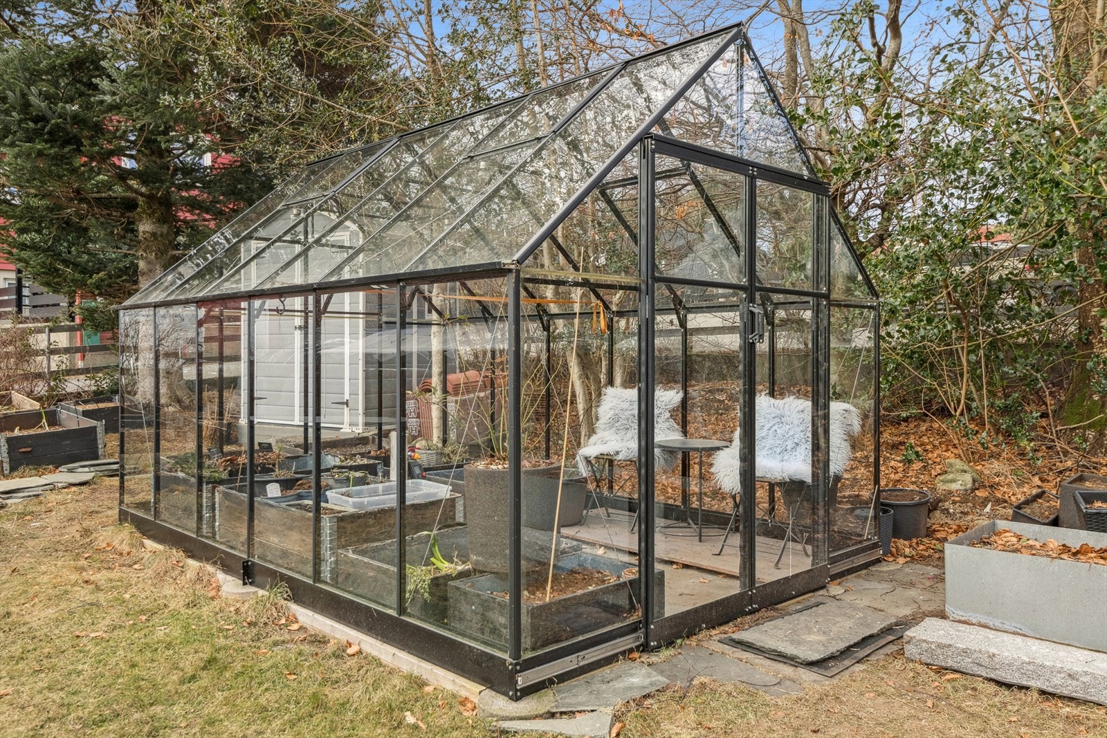 Drivhus i hagen med flotte muligheter for planting av grønnsaker og blomster. Inspirerende for dyrking, vekst og grønne hobbyprosjekter. Galleribilde