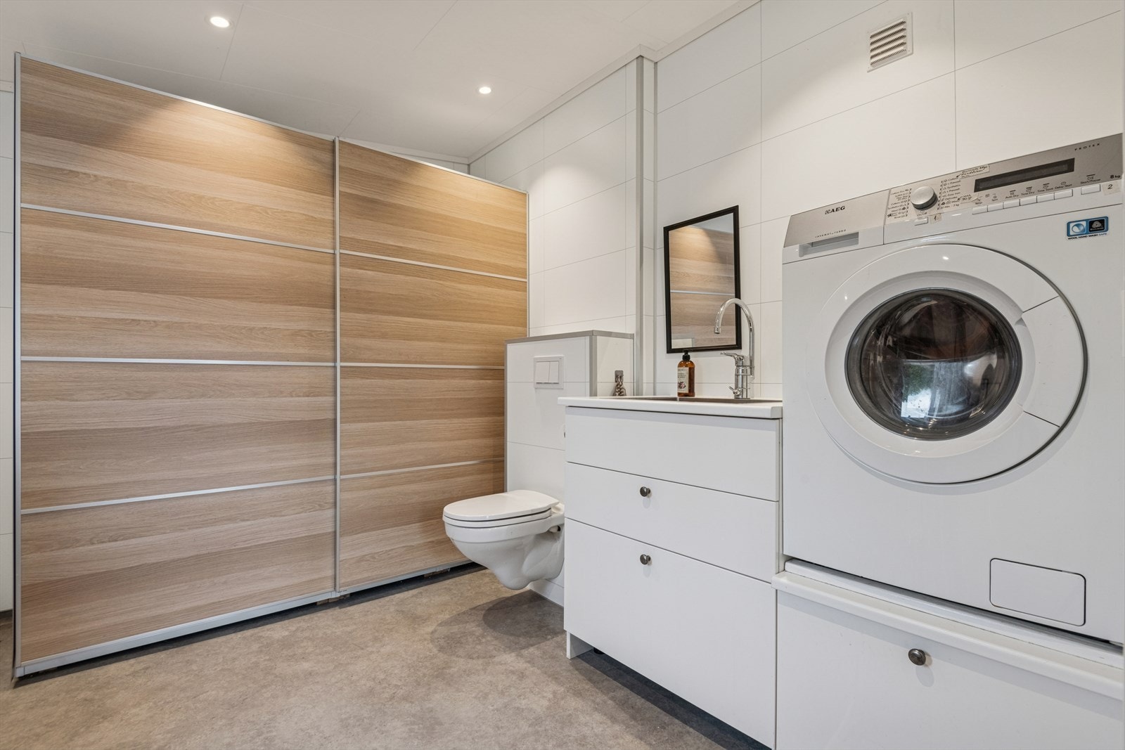 Pent baderom 1. etasje innredet med vegghengt toalett og en baderomsinnredning med vask. Opplegg for vaskemaskin. Galleribilde