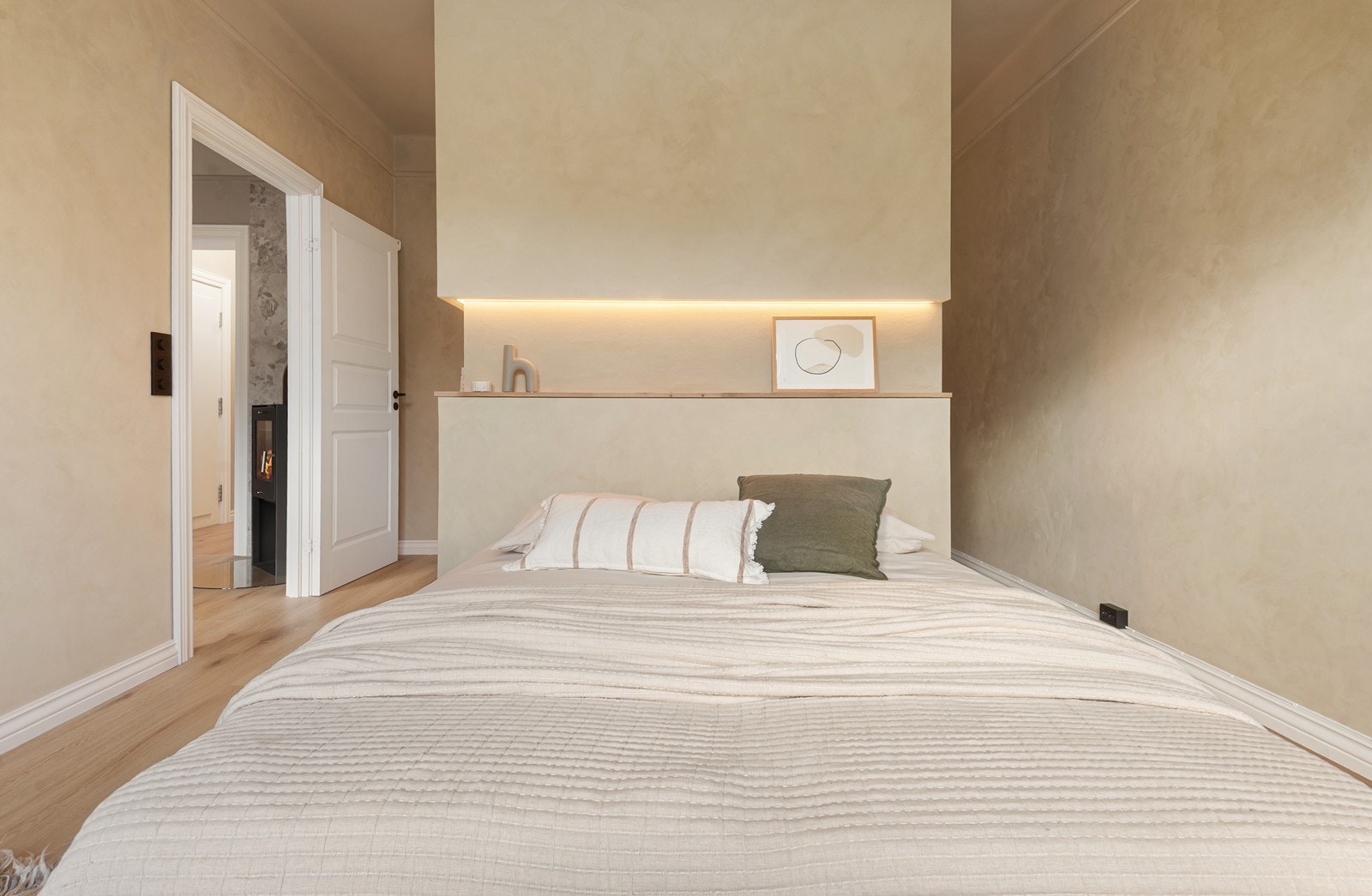 Soverommet fremstår rolig og harmonisk med lune fargetoner, integrert belysning og en helhetlig stilren og moderne finish Galleribilde