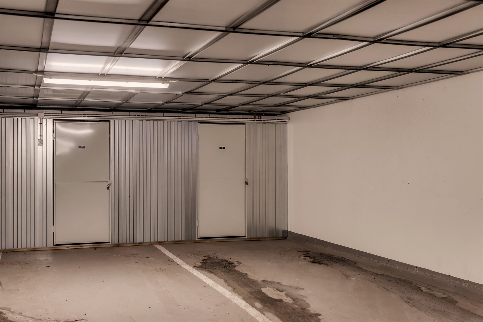 Garasjeplassen i tilknytning til leiligheten ligger i byggets kjeller, hvor heisen tar en rett ned i anlegget. Galleribilde